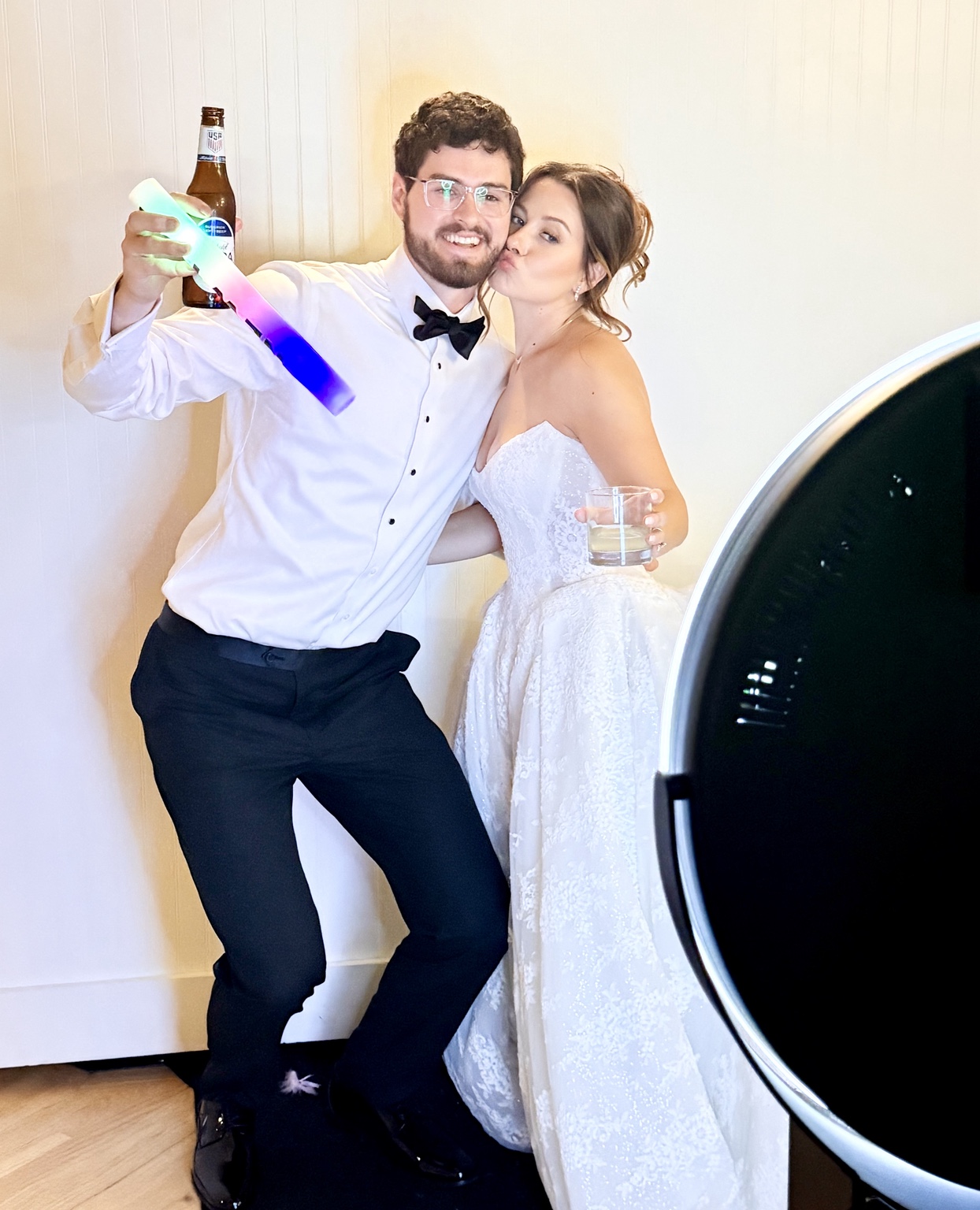 Bride and groom celebrating beside the Dream Photo Booth at a wedding